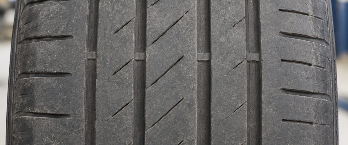 Worn tire tread with the wear bars almost level with the tread