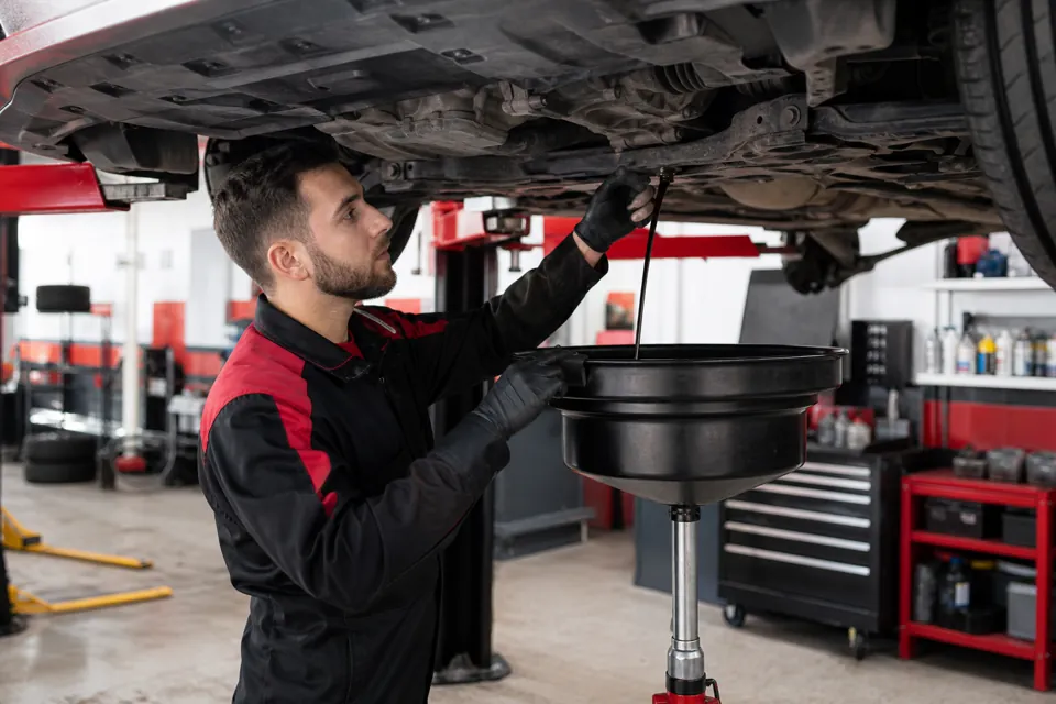 Mechanic performing oil change service in a Stittsville auto service shop