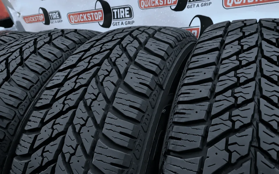New tires in front of a QuickStop Tire backdrop